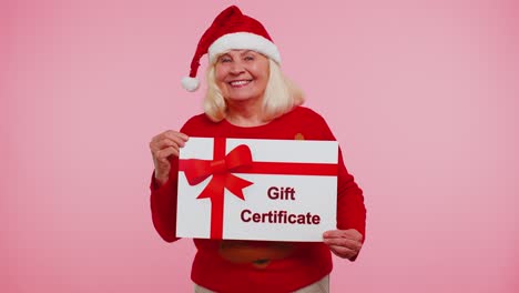 Elderly-grandmother-woman-in-New-Year-sweater-presenting-card-gift-certificate-coupon-winner-voucher