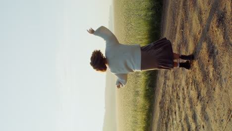 mujer bailando en un campo al amanecer
