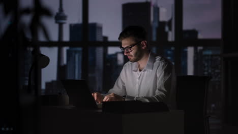 dedication is what earns the best results. businessman in office working at desk on laptop. man student writer sit at office desk with laptop thinking of inspiration search problem solution ideas
