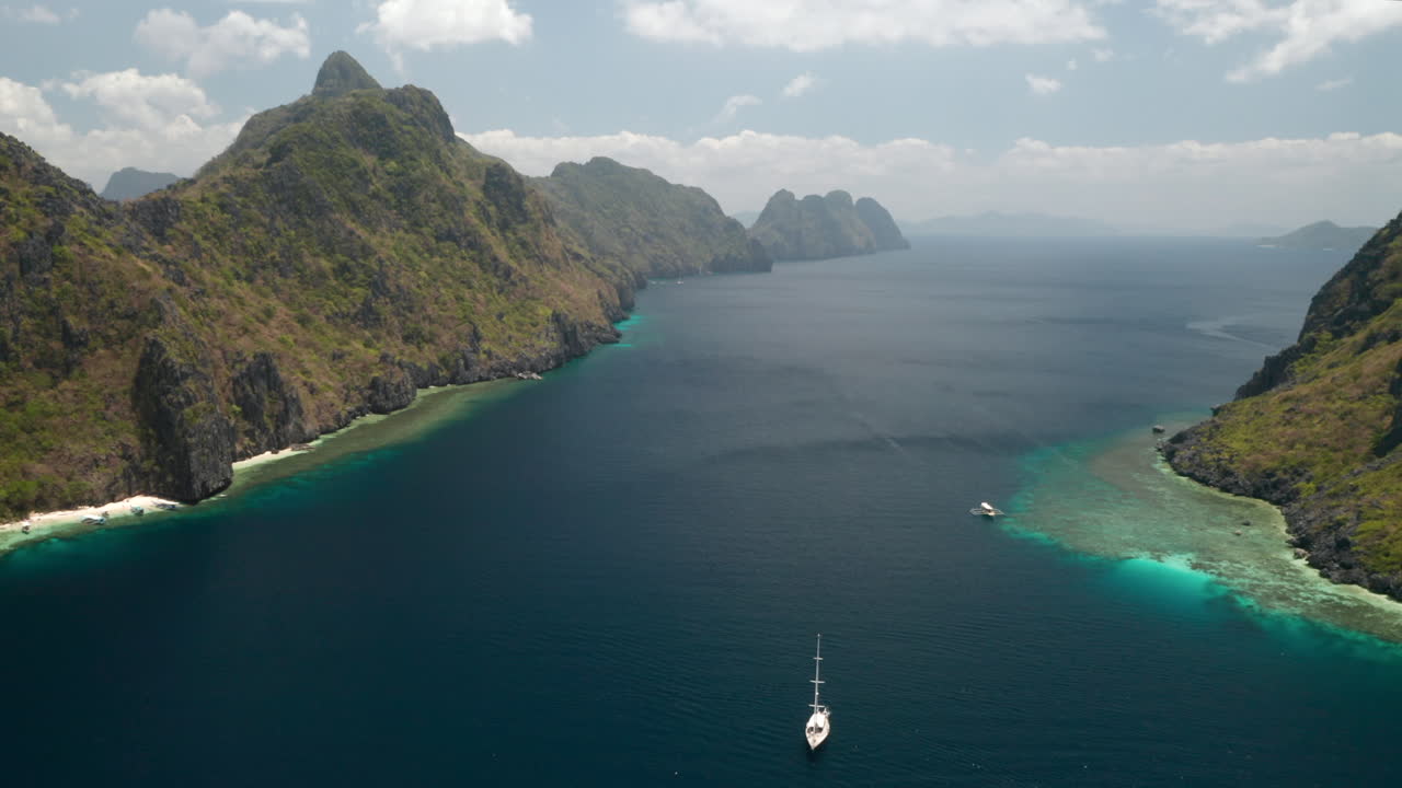 vuelo aéreo sobre un velero por la isla matinloc, el nido, palawan, filipinas