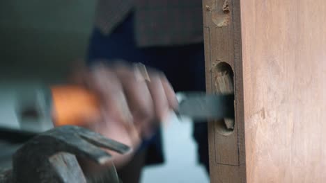 carpenter chiselling a door in a house