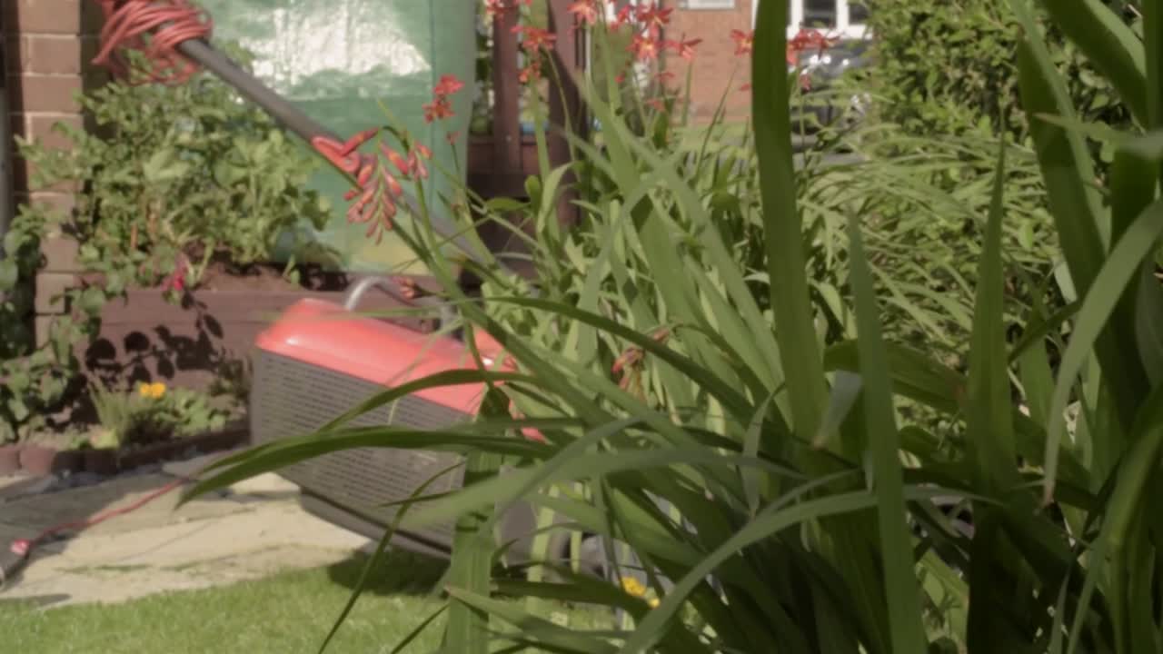 dueño de casa cortando el césped en un día ventoso