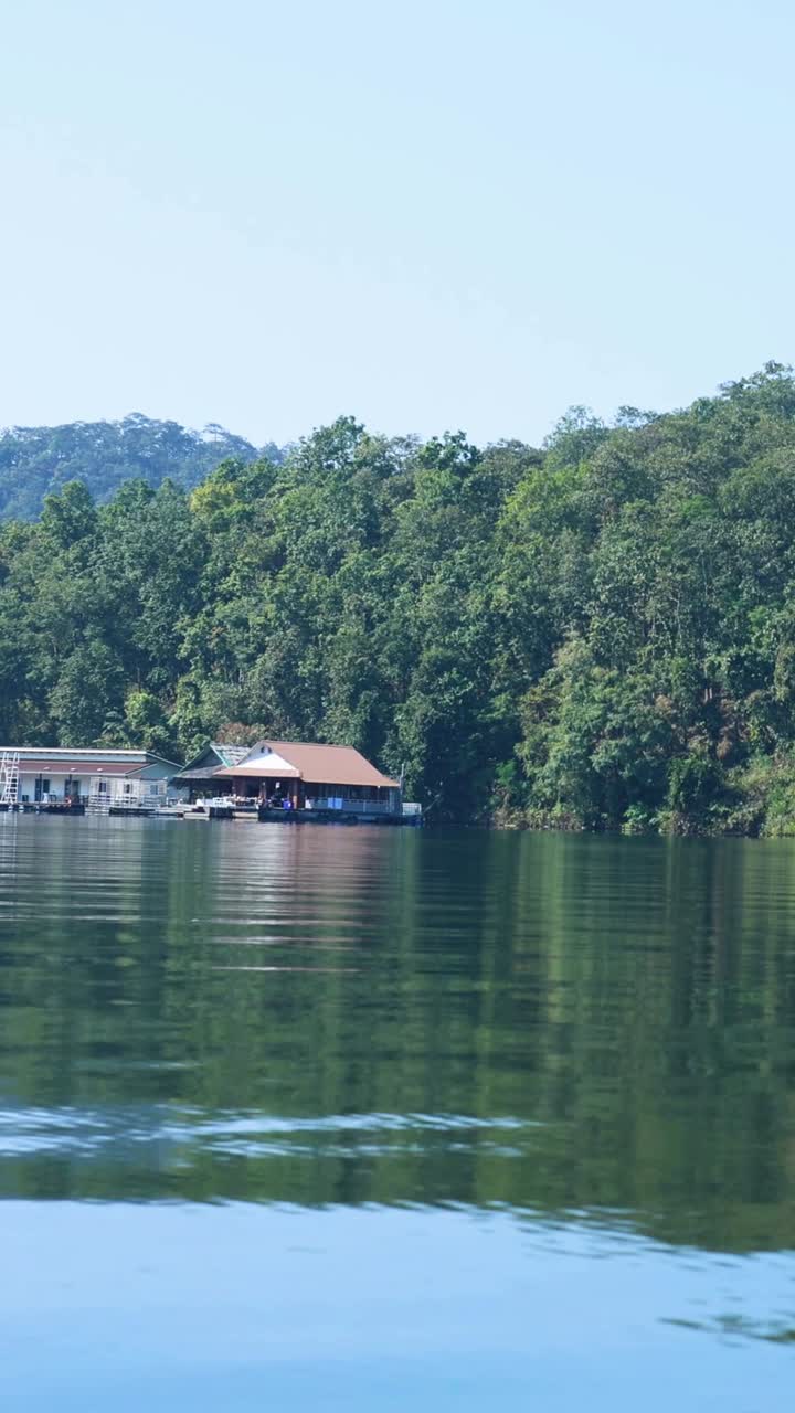 agua tranquila, casas flotantes, vegetación exuberante, cielo despejado