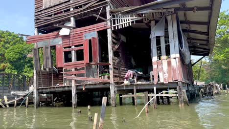 a rustic house on stilts by the water