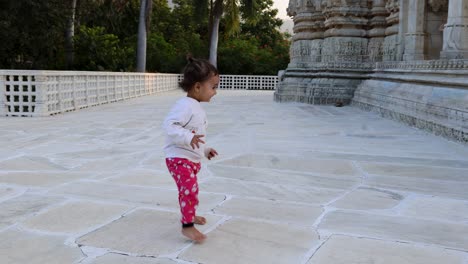 cute toddler walking at temple courtyard at day from unique perspective