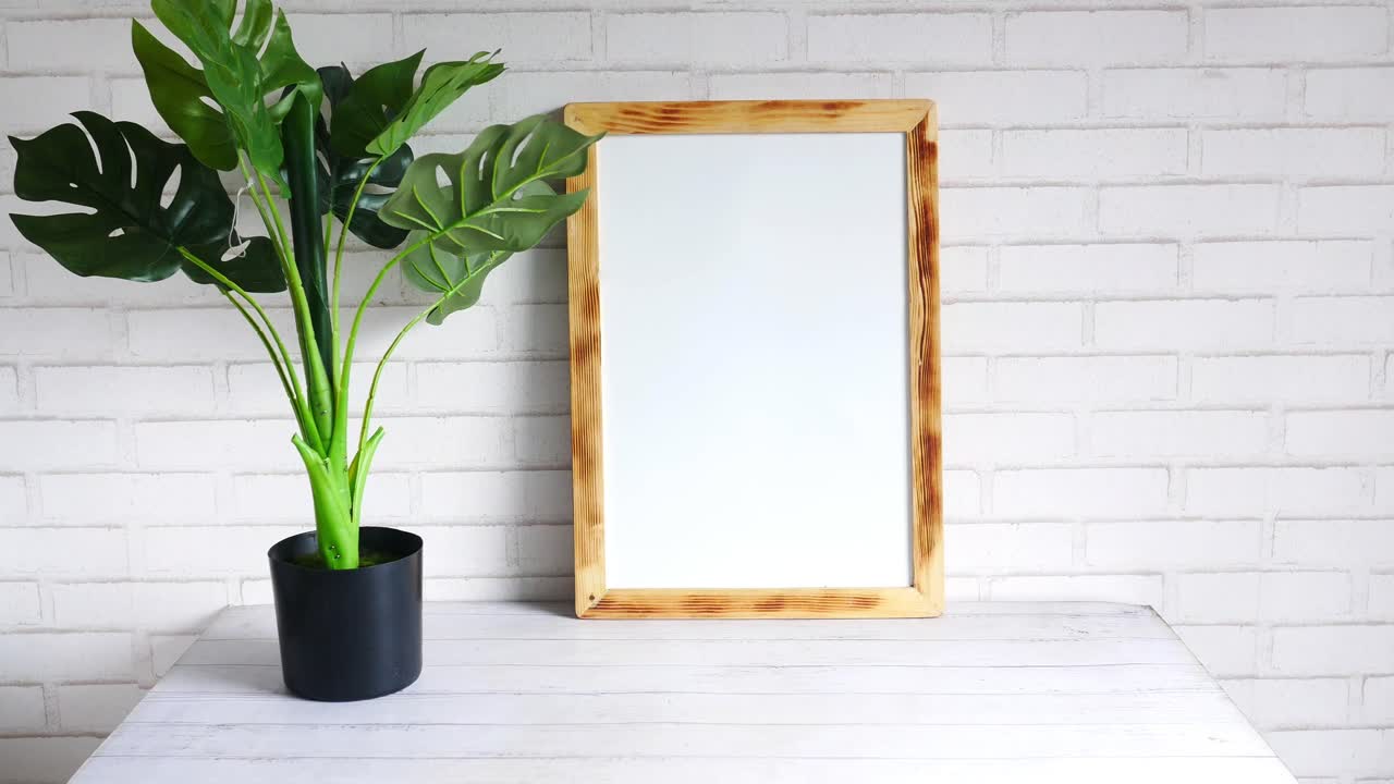 marco de madera en blanco con planta de monstera