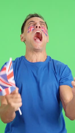 Man cheering for United Kingdom screaming and waving a national flag
