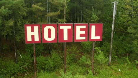 Red-sign-that-says-"Hotel"-in-an-abandoned-parking-lot