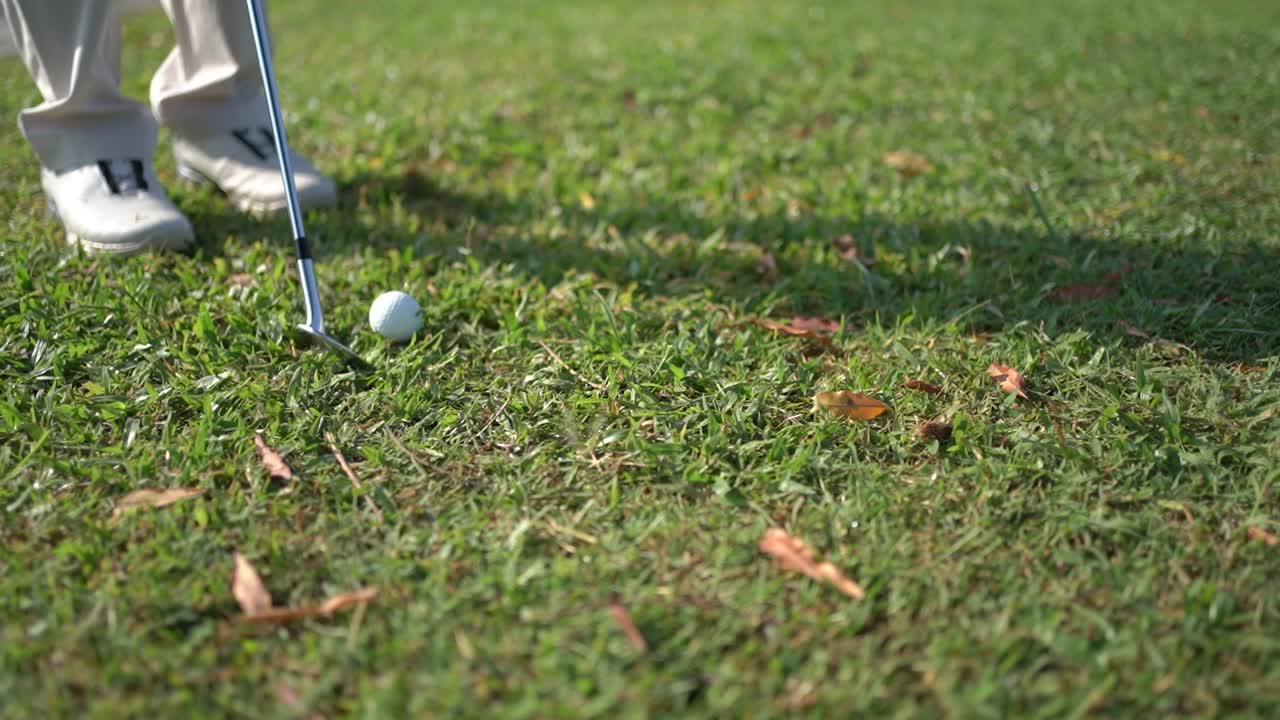 공에 가까이 가서, 골퍼는 막대기로 공을 때립니다.