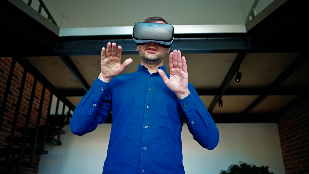 Man gesturing while using a Virtual Reality headset in an office