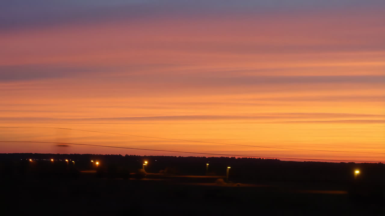 Vibrant Sunset Horizon with Distant Lights and Motion Blur