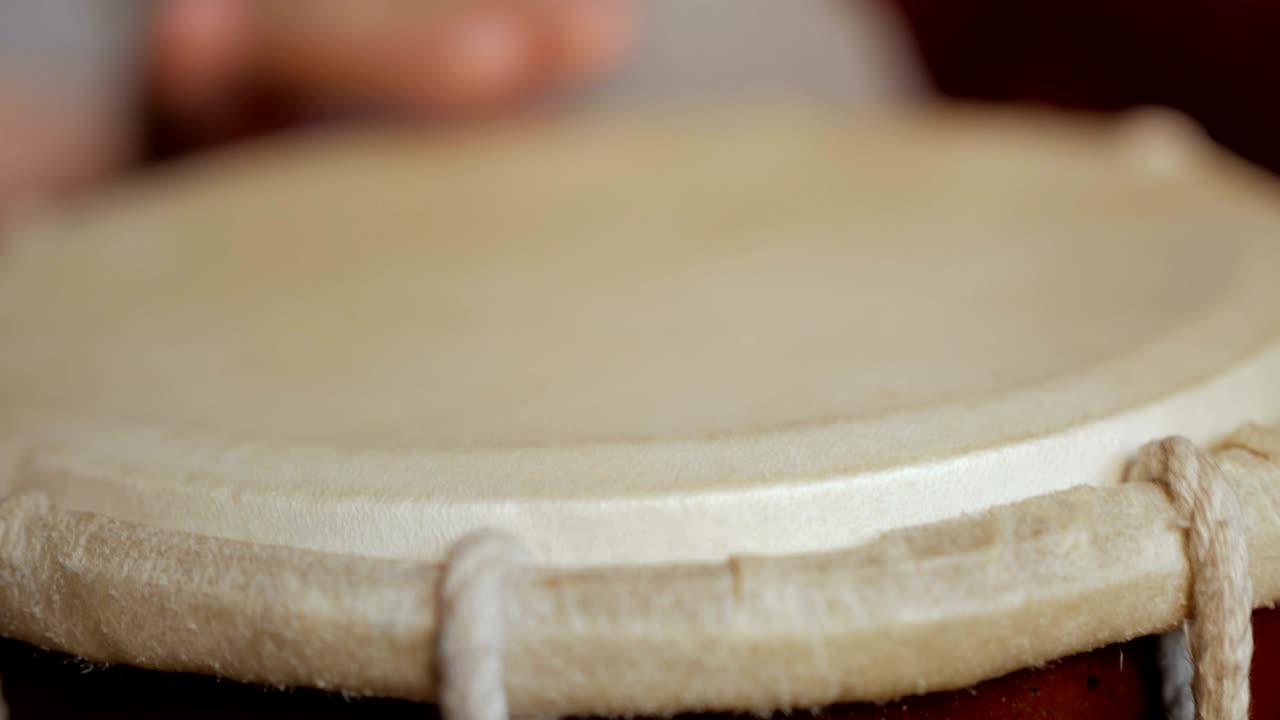 cerca de las manos de un hombre tocando un tambor.