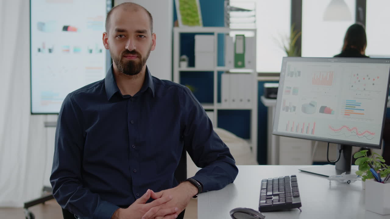 Portrait of businessman sitting at desk with computer