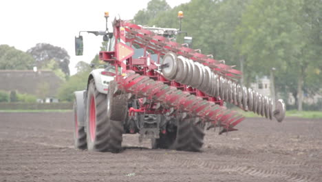 Tractor-with-big-plow-driving-over-land