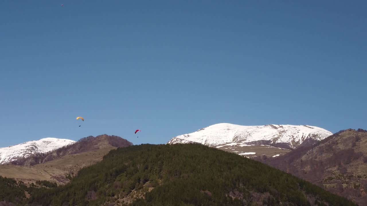 Paragliders high in the sunny sky from drone footage 4k