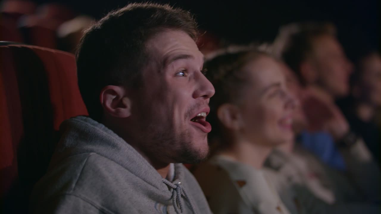 Man laughing at comedy film. Male emotion at movie entertainment