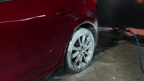 red car being washed in detailing garage
