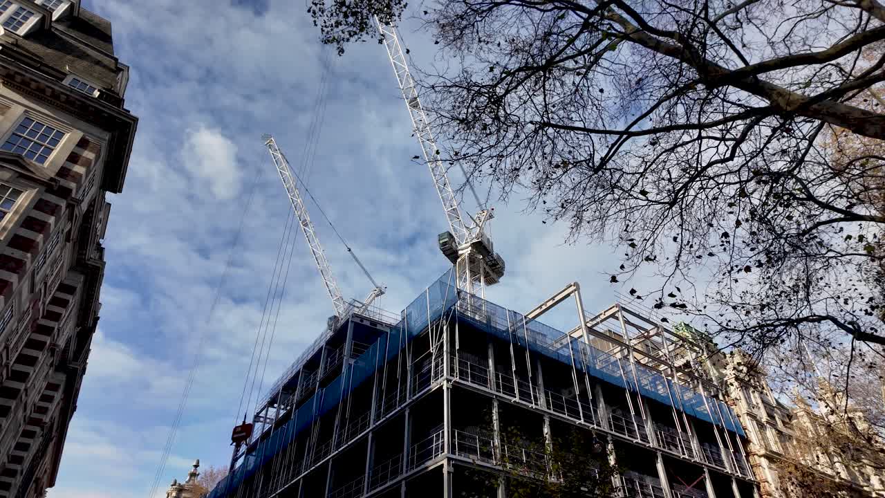 Construction site with cranes in Millbank Westminster London showing a building under construction against a cloudy sky