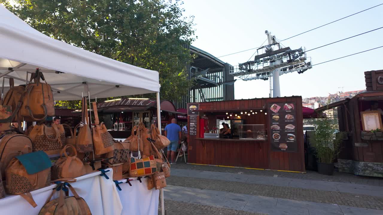 Outdoor food market near Vila Nova de Gaia with a historic building and cable cars in the distance
