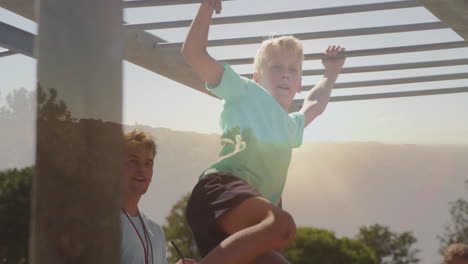 playing on monkey bars, child with another child watching at playground