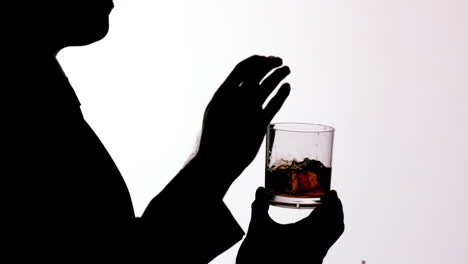 Silhouette-Eines-Geschäftsmannes,-Der-Eis-In-Ein-Whiskyglas-Gibt