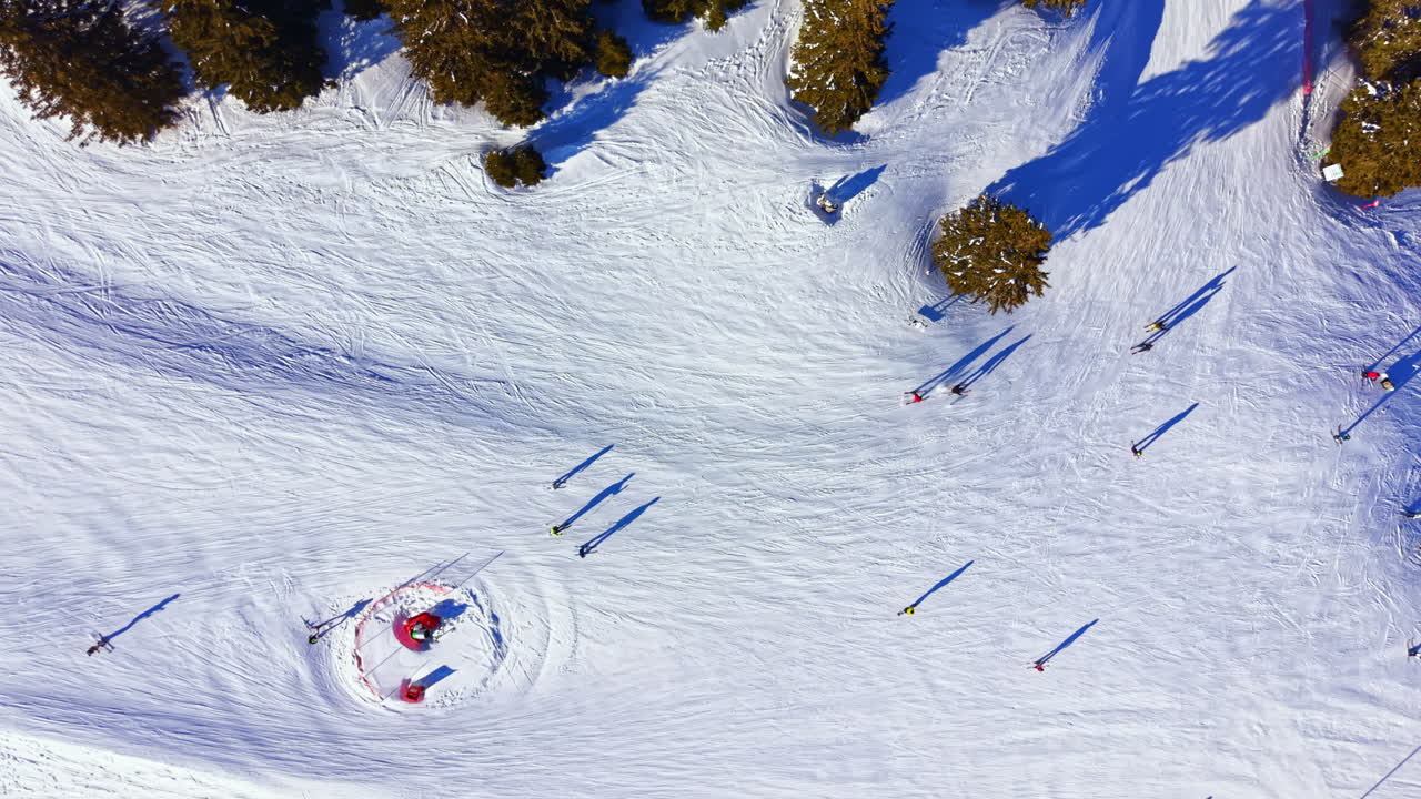 Aerial View of Skiers Descending a Snowy Mountain Slope