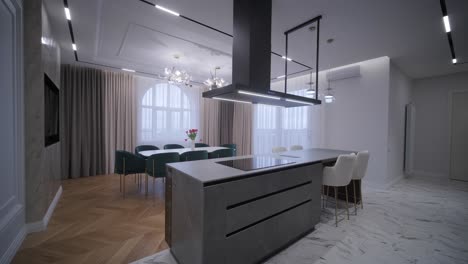 luxurious open-plan living space with herringbone wood flooring, a marble kitchen island, and a mix of classic and modern lighting fixtures for a chic, airy feel