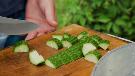 Primer-Plano-De-Las-Manos-Del-Hombre-Cortando-Pepino-Con-Un-Cuchillo-En-Una-Tabla-De-Madera