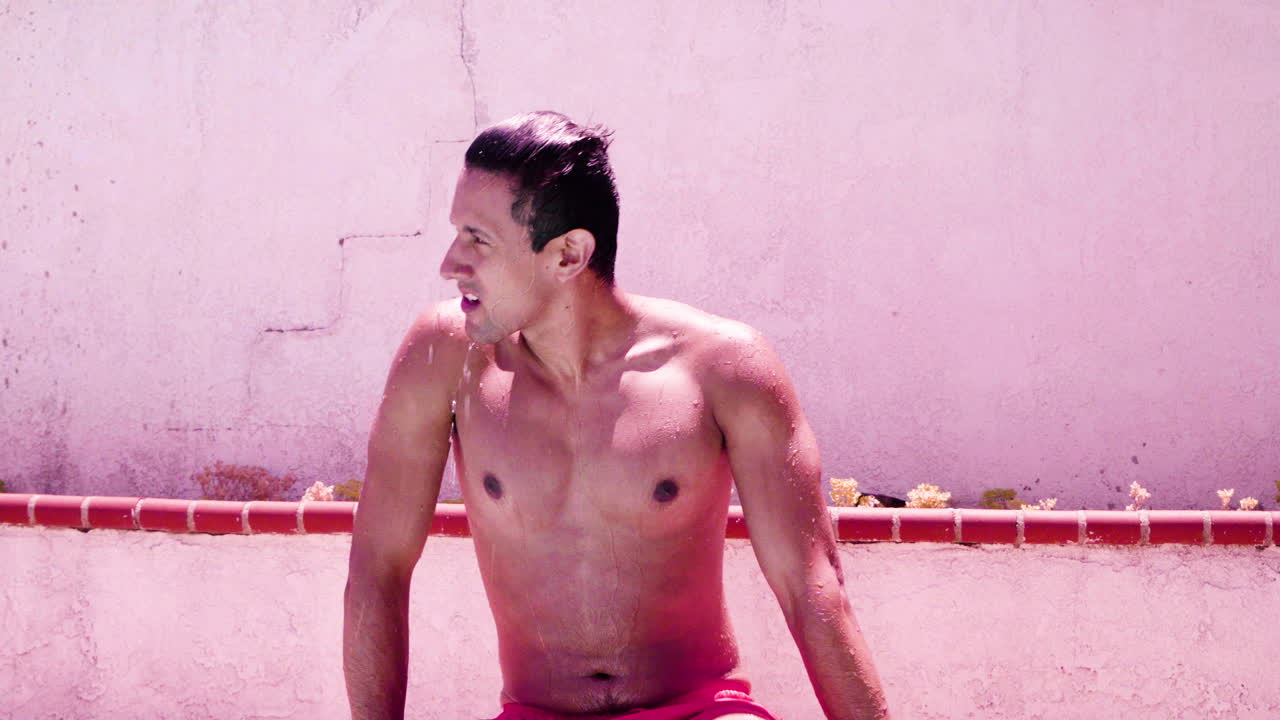 Male enjoying the sun exiting the pool to sit poolside