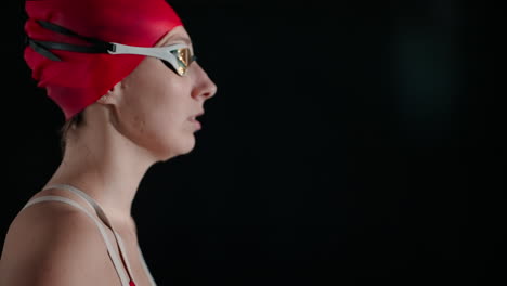 a woman in a red swimsuit prepares to dive into a swimming pool.