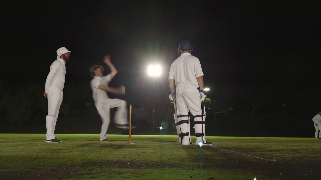Un lanciatore di cricket lancia la palla, il battitore reagisce, il giocatore di campo raccoglie la palla, il gioco riprende e le luci brillano.