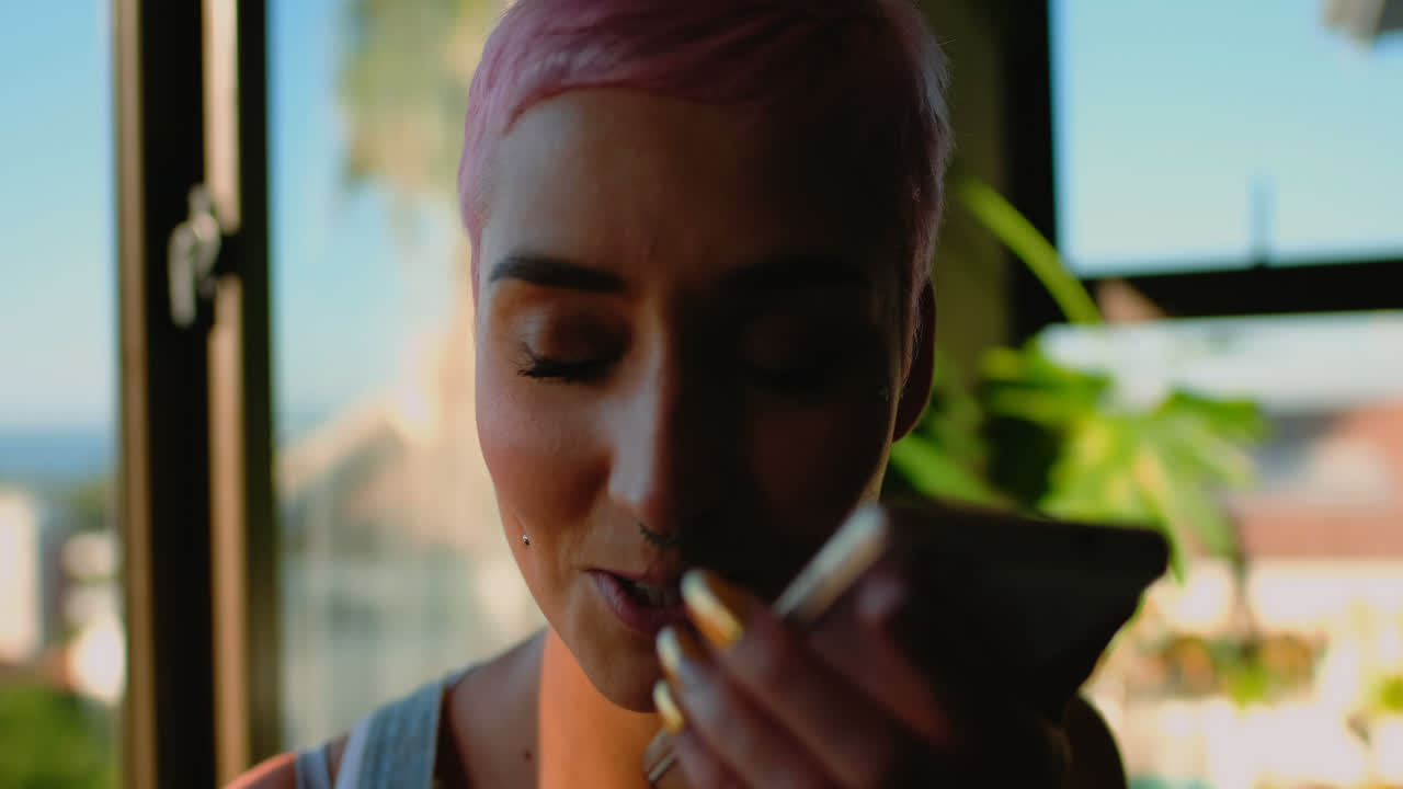 mujer de cabello rosa hablando por teléfono móvil 4k