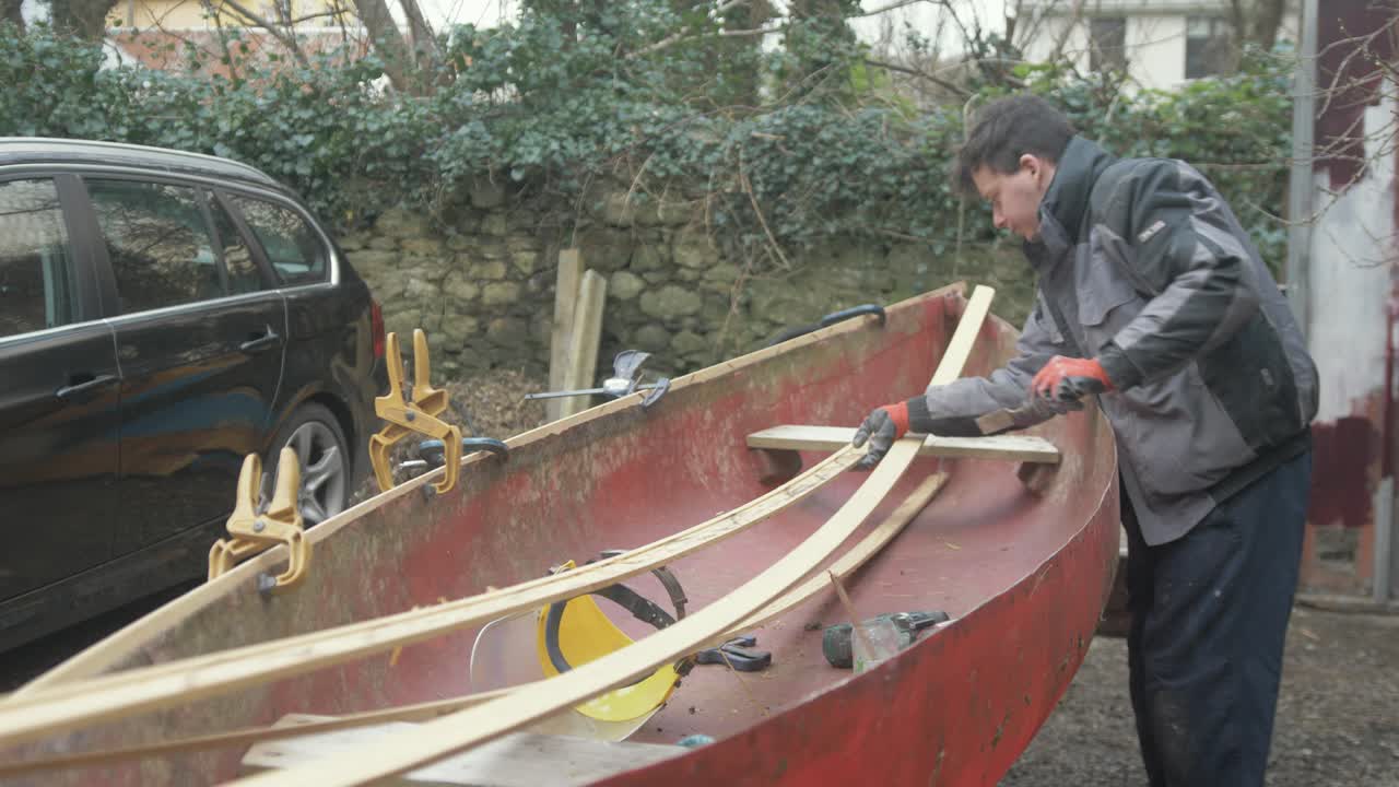 preparación de la borda de madera dura de teca para la fijación en una canoa de fibra de vidrio