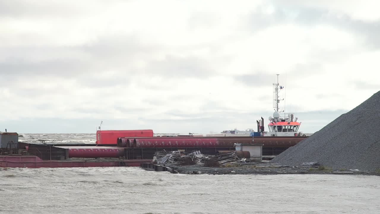 폭풍이 불어오는 항구에서 바지와 견인선 운항