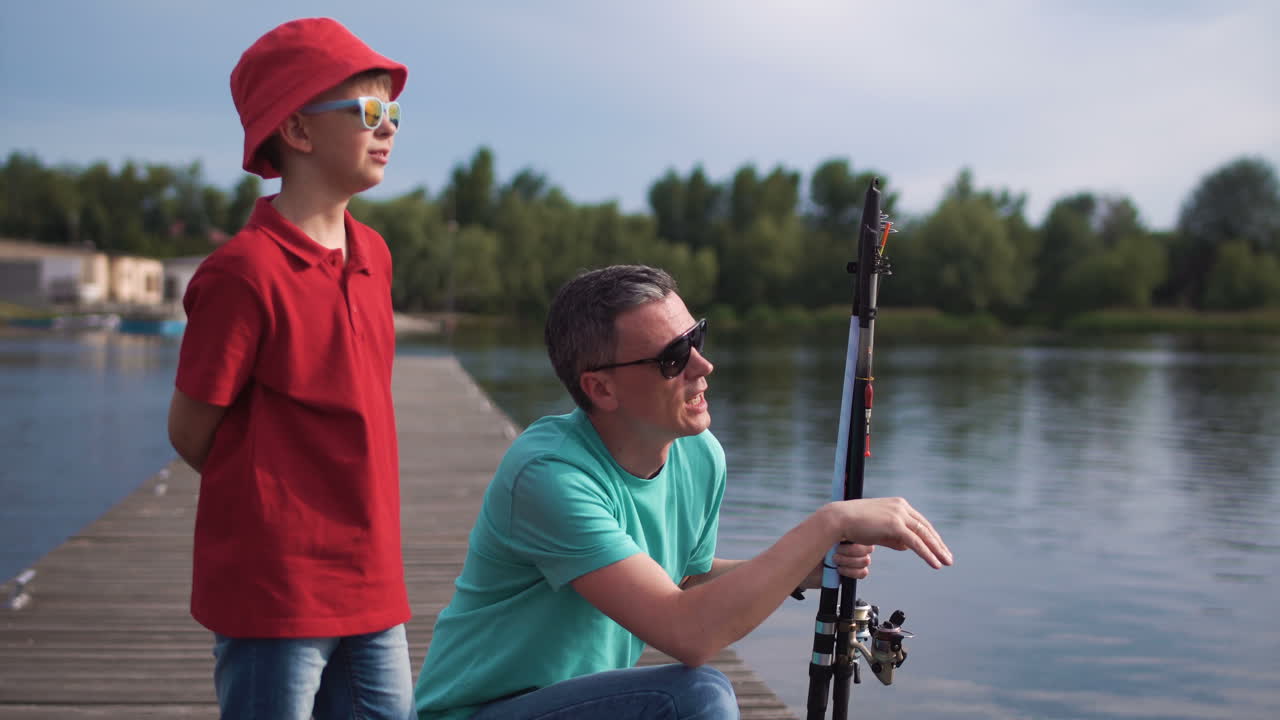 Отец и сын ловят рыбу.
