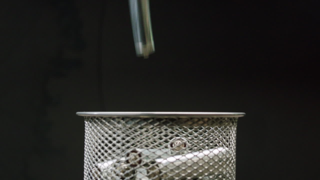 Silver batteries AA and AAA falling into wastebasket close-up. Double-A battery is a standard size single cell cylindrical dry battery. Batteries are common in portable electronic devices. Environmental impacts of lithium-ion batteries concept. An AA battery is composed of a single electrochemical c