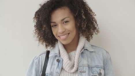 Afro-American-girl-in-casual-clothes-is-looking-at-camera-and-smiling