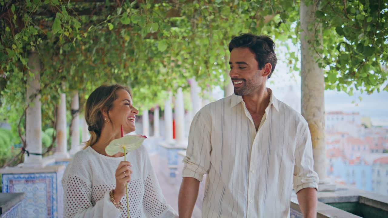 로맨틱한 배우자들이 골목길을 걸어다니며 가까이에서. 커플이 녹색 테라스를 고 이야기하고 있다.