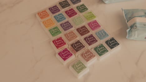 close up of colorful ink pads labeled baby story arranged on a light marble surface