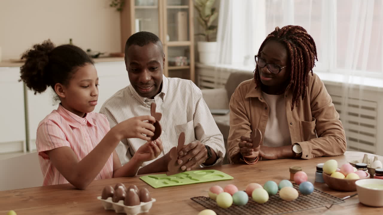 Família Brincando com Figuras de Chocolate.