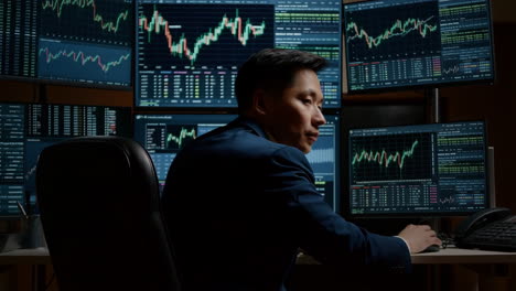 financial trader analyzing stock market data on multiple monitors
