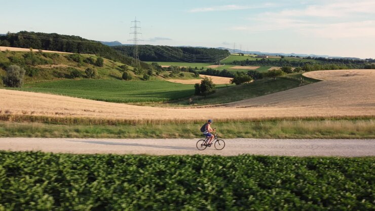 ciclista su una strada di ghiaia rurale in estate