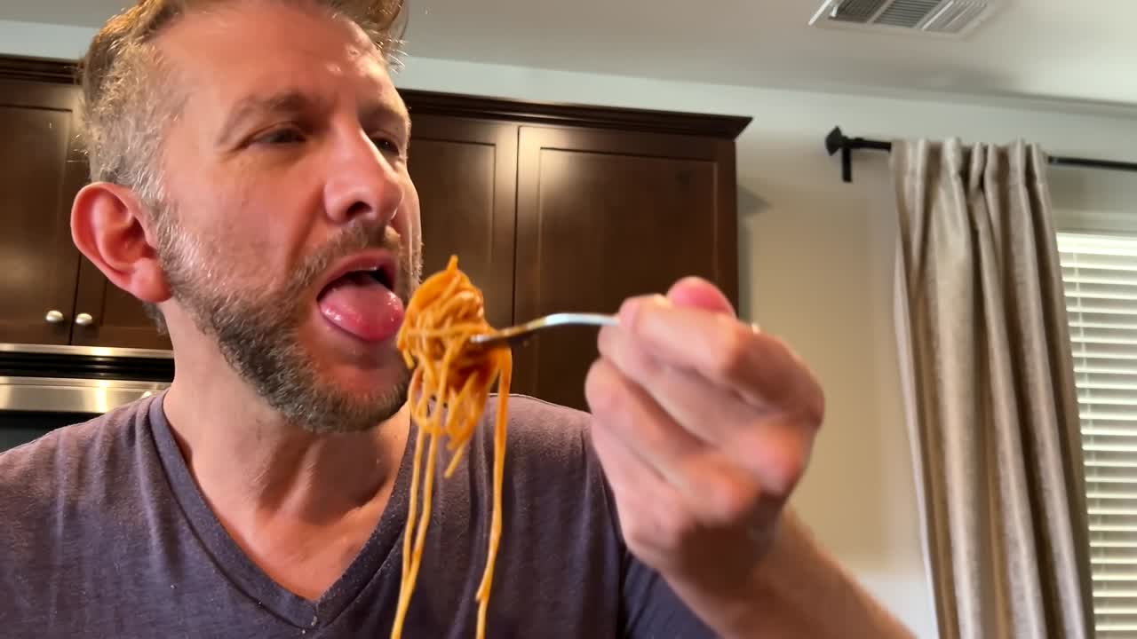 el hombre come un gran bocado de pasta y se siente culpable porque es calórico