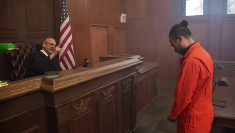 zoom out from judge scolding an inmate during court room trial