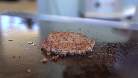 ein stück burger auf dem grill zubereiten - nahaufnahme