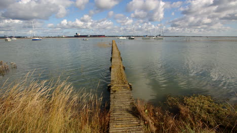 extra wide mid shot of a long wooden jetty with flooding debris on top