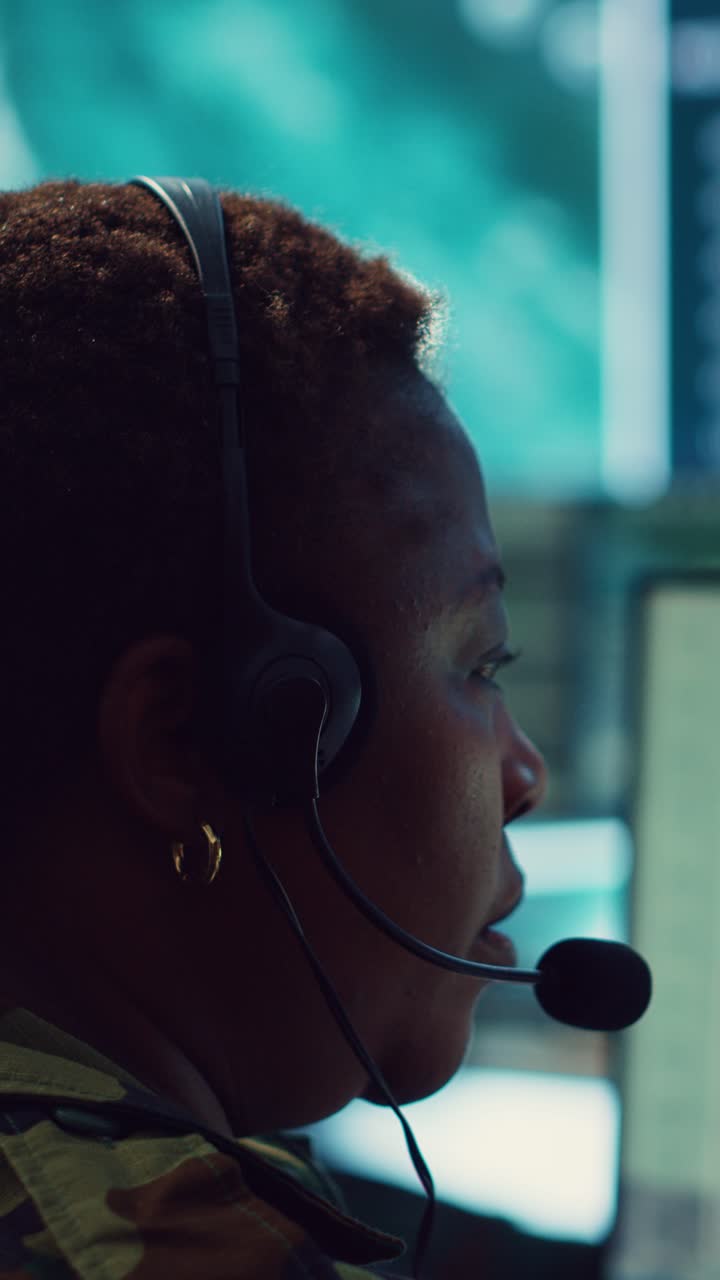 Fokusert kvinne med headset som kommuniserer i et kontrollrom