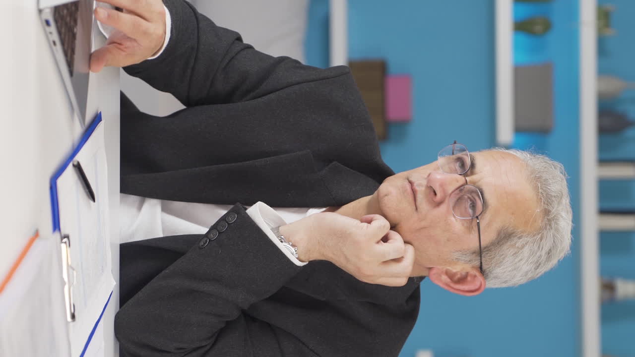 Vertical video of Home office worker man working seriously and focused.