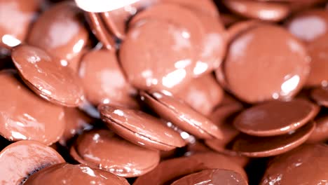 spoon stirring shiny chocolate discs together