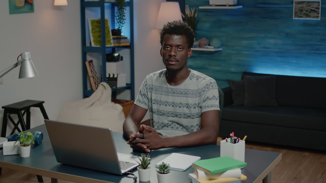African american man smiling and working on laptop